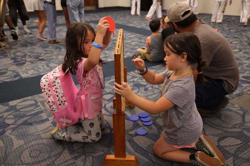 Two little students having fun playing checkers