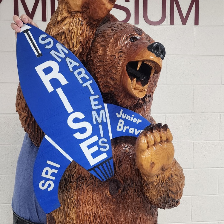 Mascot Bear holding Smartemis cutout rocket. 