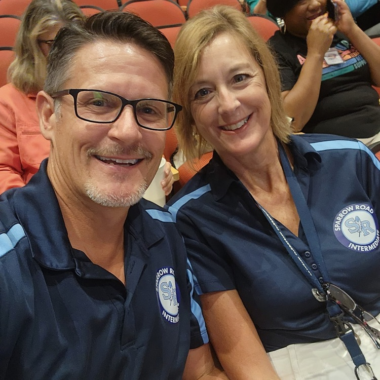 Mr. Triolet and Mrs. Boerboom smiles together at the conference. 