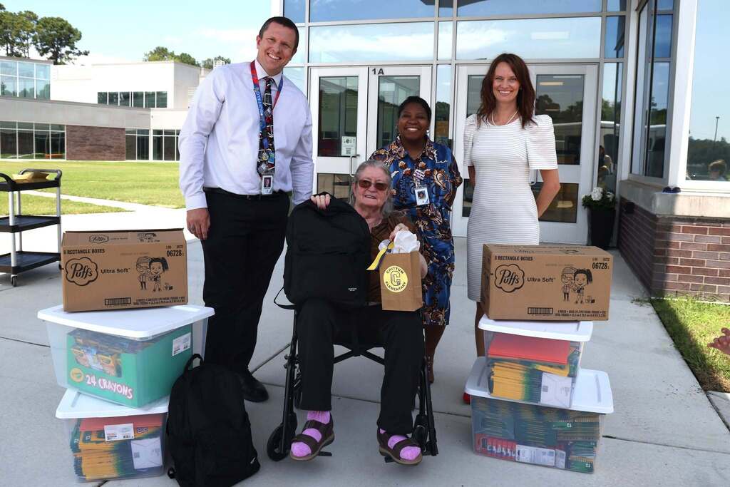 Ms. Chittum smiles with administration and collected supplies