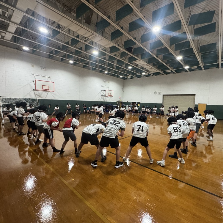 football team in a circle stretching and warming up