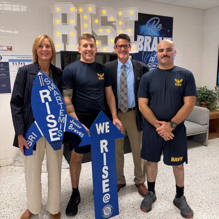 Navy volunteers with admin standing with We RISE arrow and Smartemis rocket.