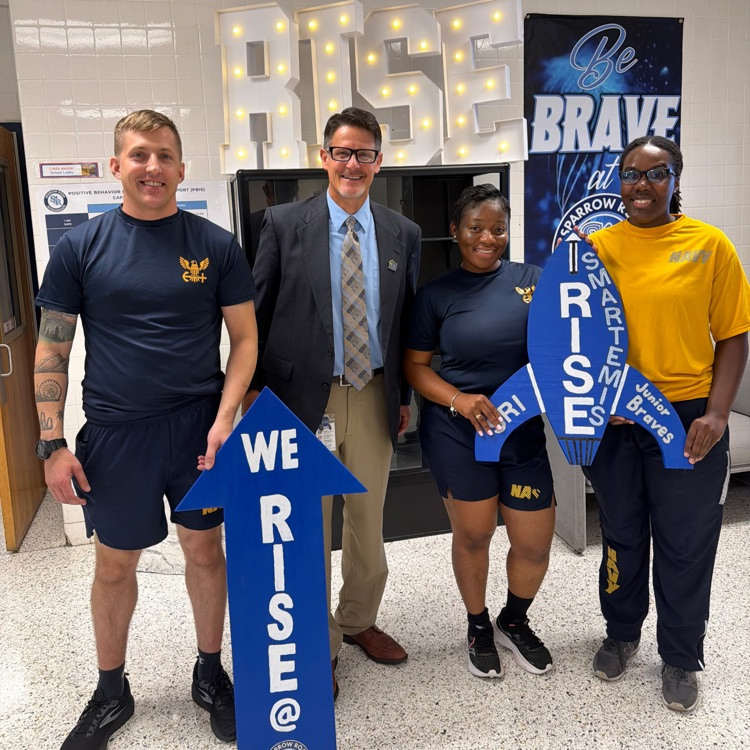Navy volunteers with Mr.Triolet standing with We RISE arrow and Smartemis rocket.