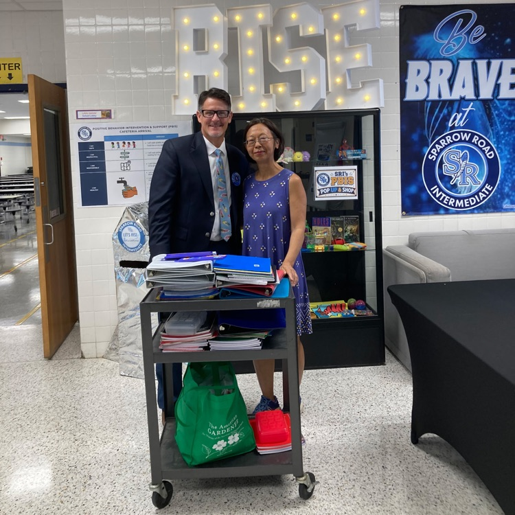 Mr. Triolet and the YMCA volunteer with school supplies on a cart.