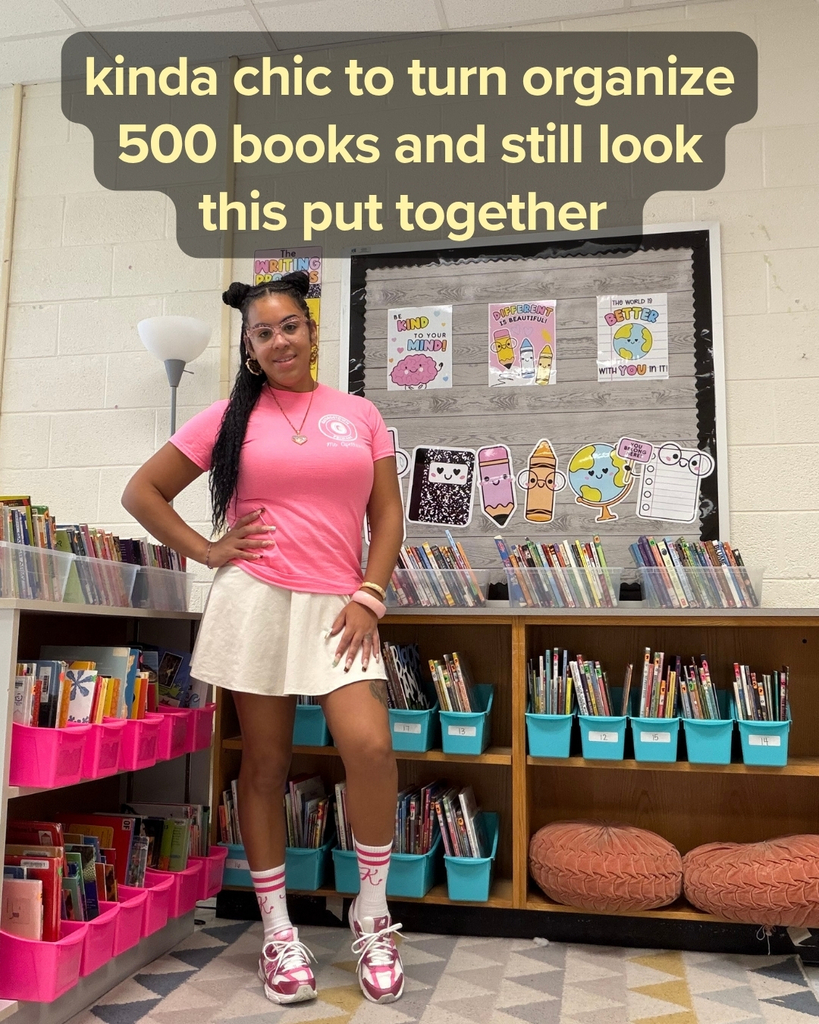 Ms. A posing in front of the classroom library - Kinda chic to organize 500 books and still look this put together