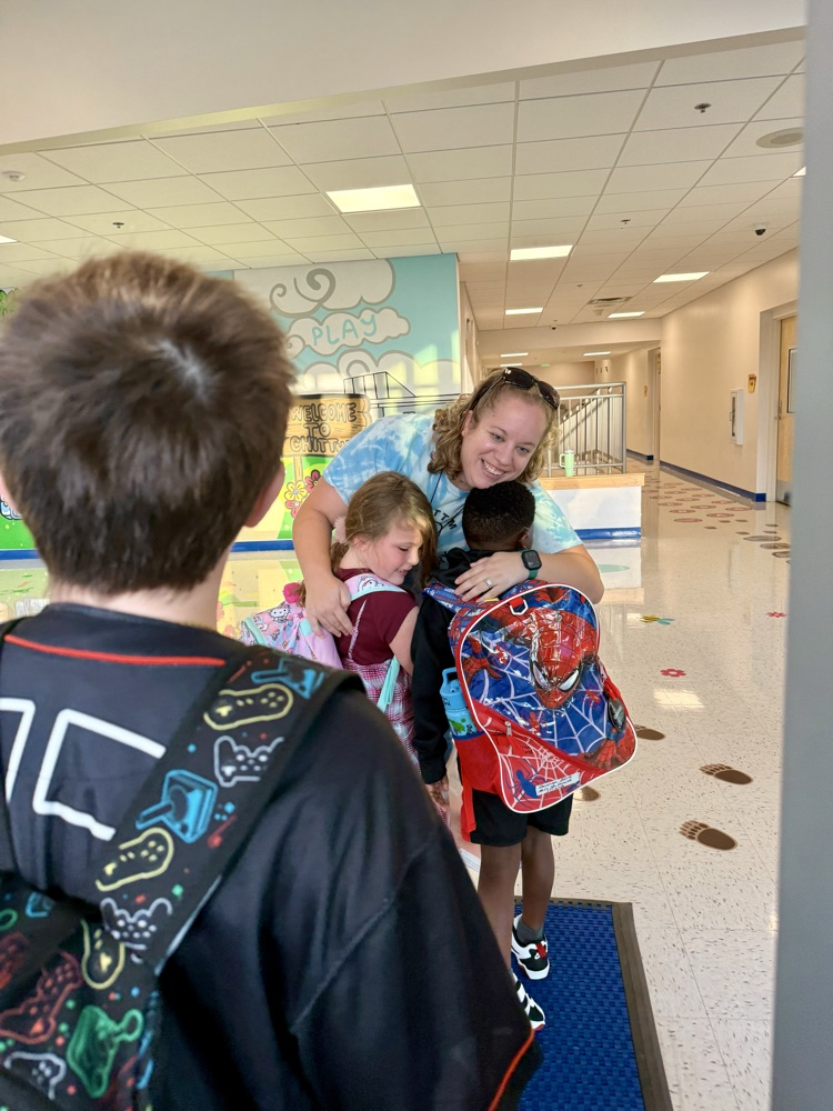 Teacher hugging students on the first day of school