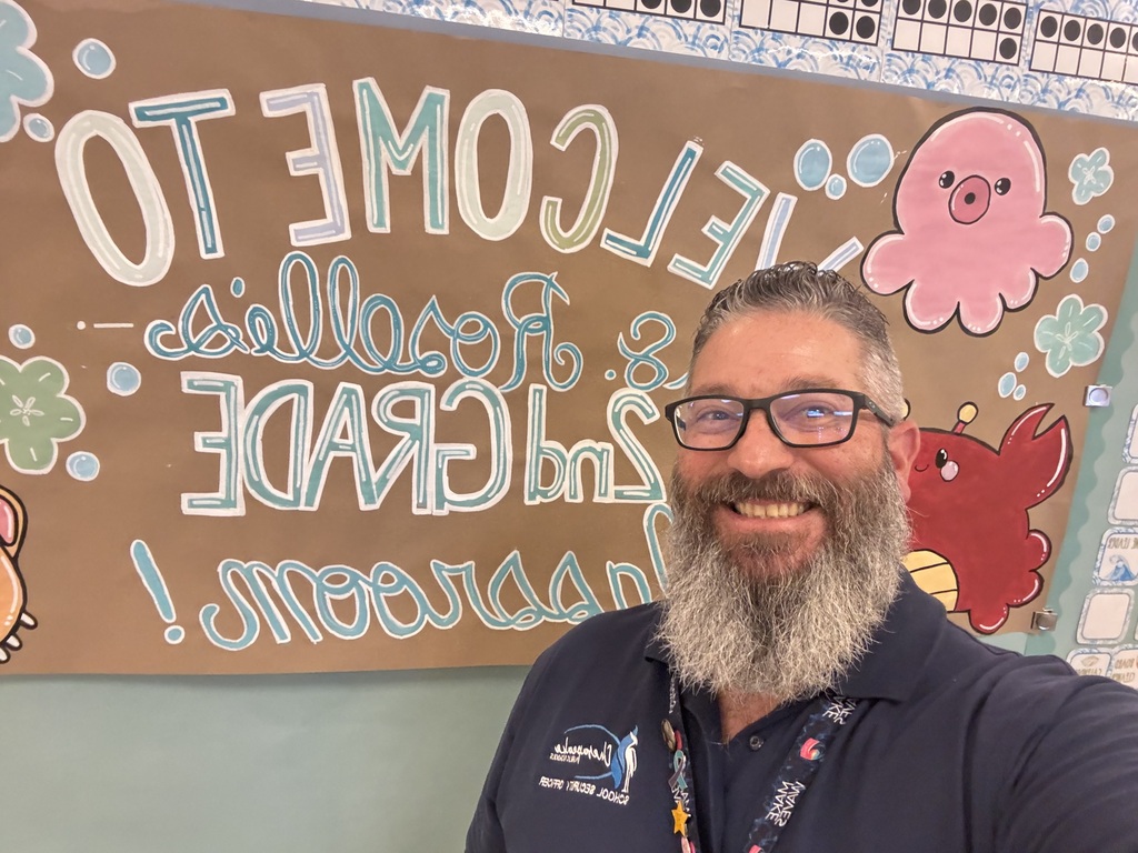 SSO posing with welcome to Ms. Roselle's second grade class sign