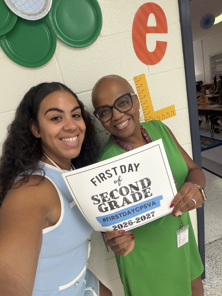 staff pose with first day of second grade sign