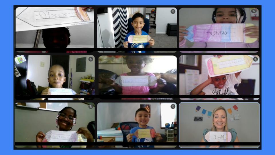 students holding up assignment and smiling 