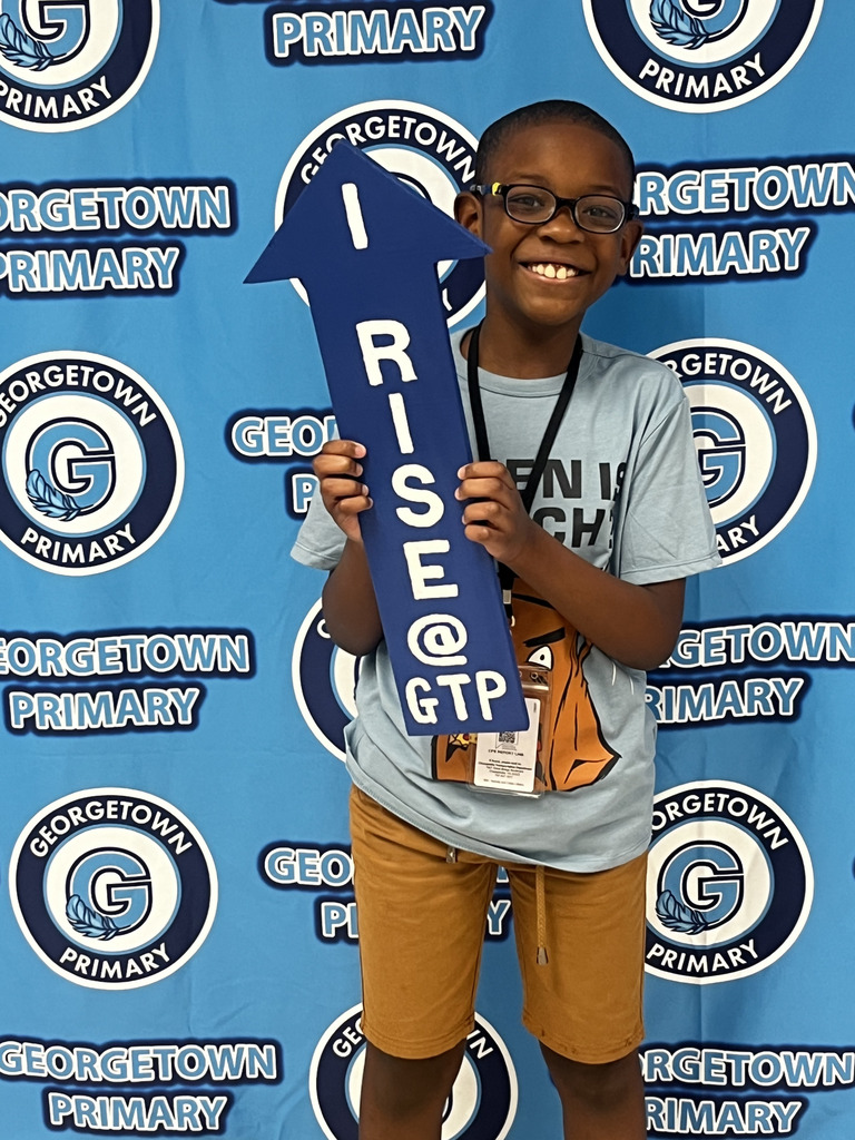 student poses with I RISE arrow for his positive office referral