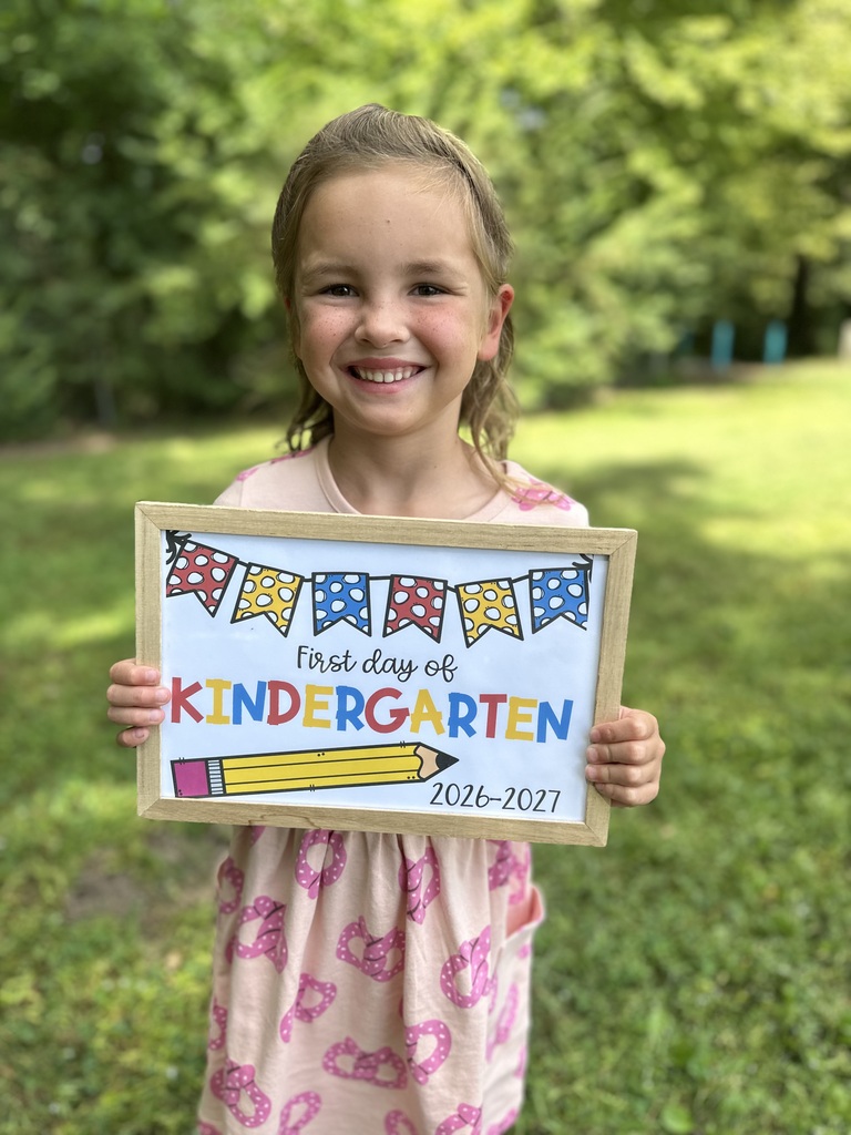 kindergarten student holding first day of school sign