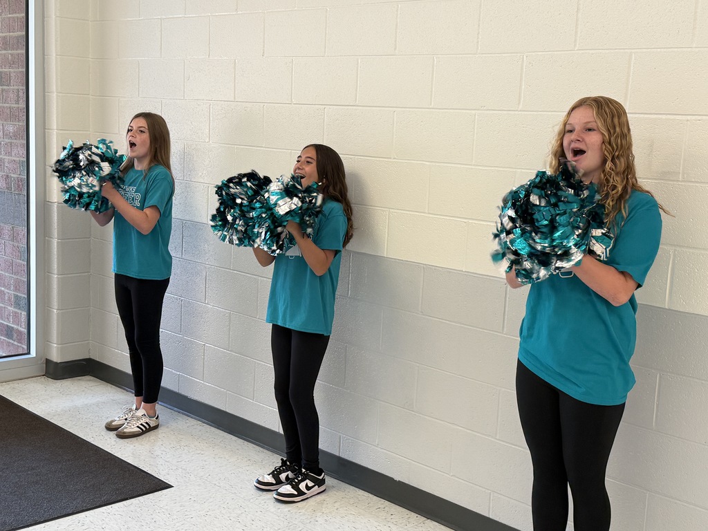 cheerleaders cheering at the bus ramp of the school