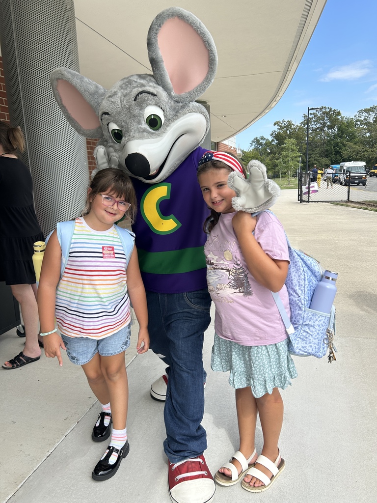 Students posing with Chuck E. Cheese to promote the PTA fundraiser at parent pick up.