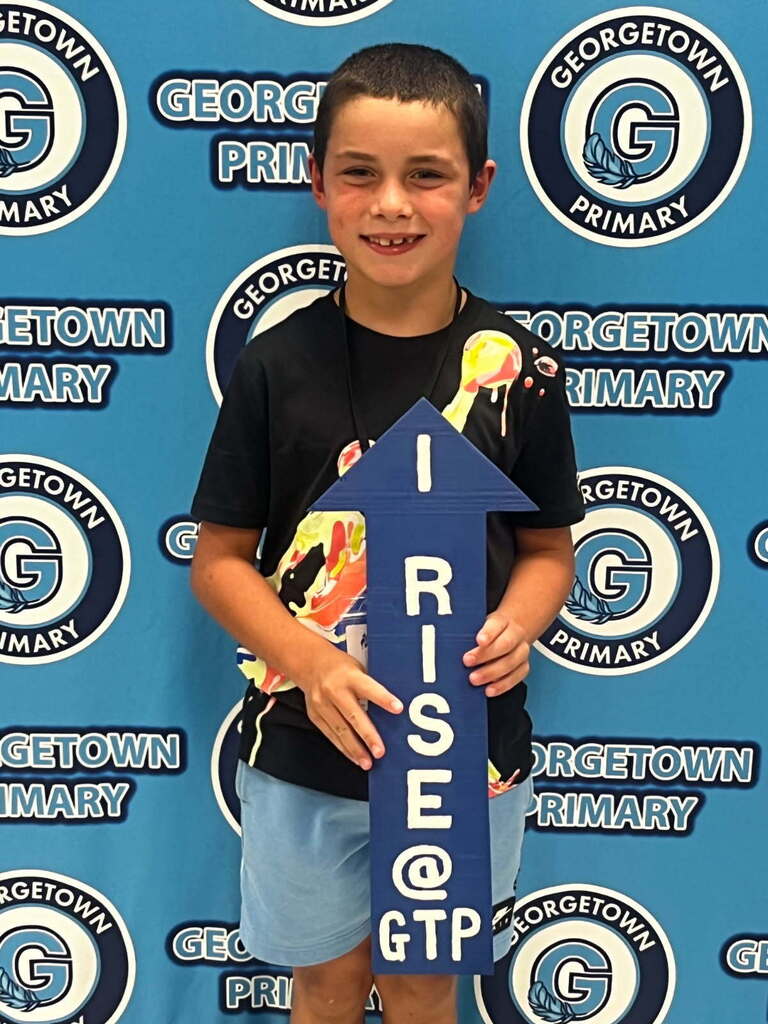student poses with I RISE arrow for postiive office referral