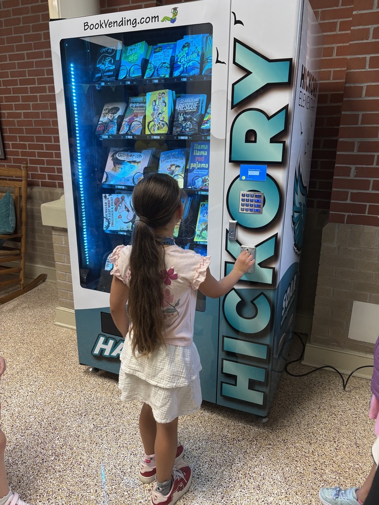 student picking a book from the book vending machine