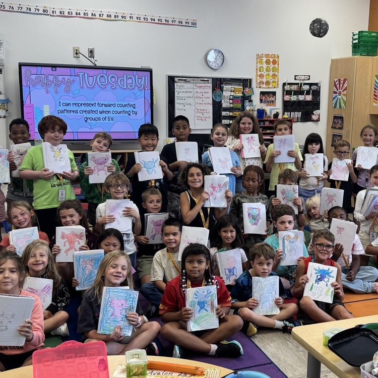 Mrs Addington and Mrs. Alvis’ class proudly showing off the axolotls they drew as their first class reward.