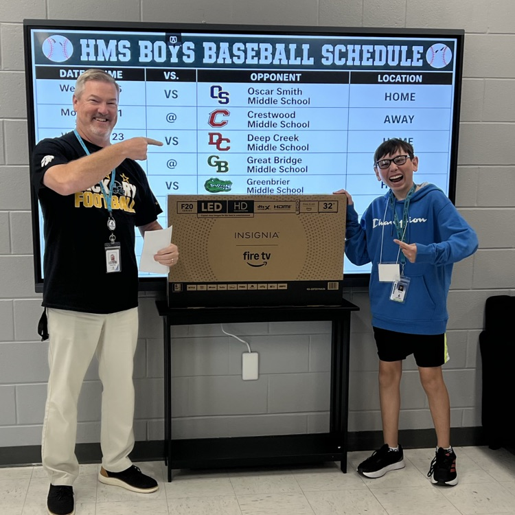 student standing proudly with his prize