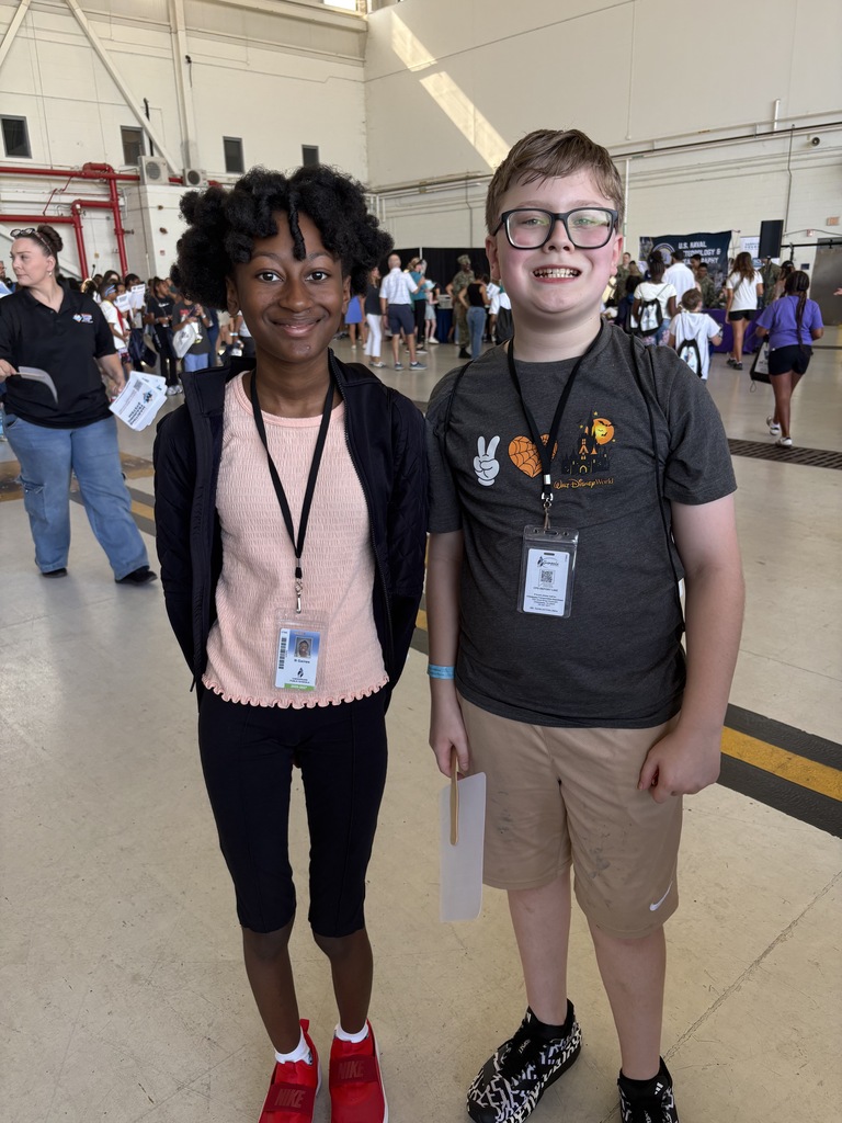 Two students smiling in the STEM hanger at the Oceana Air Show.