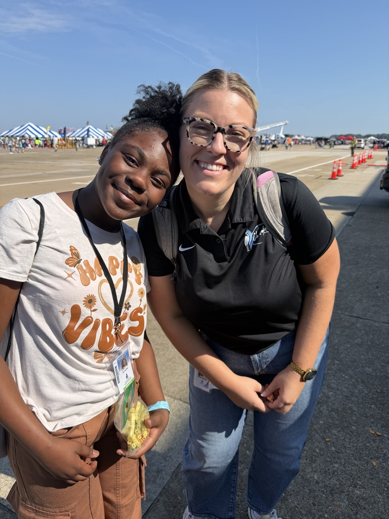 Student and teacher smiling together.