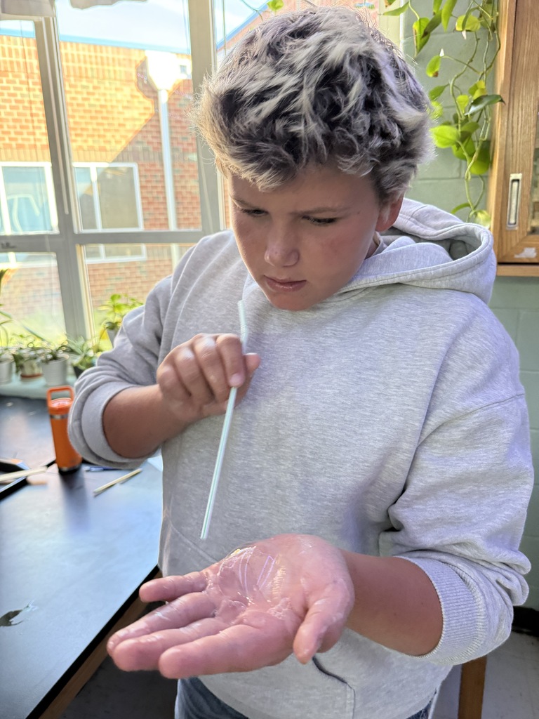 student blowing a bubble in his hand