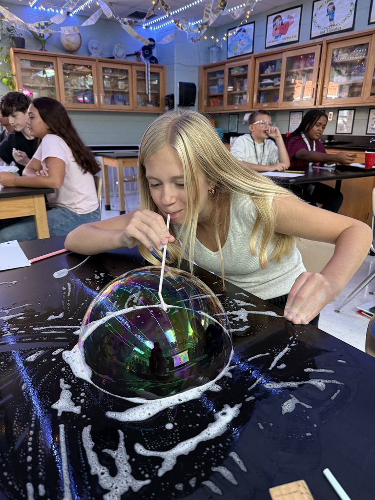 student blowing a bubble on the desk