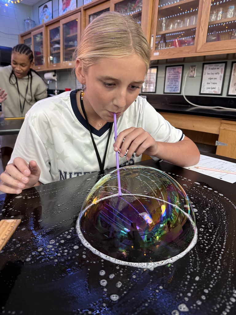student blowing a bubble on the desk