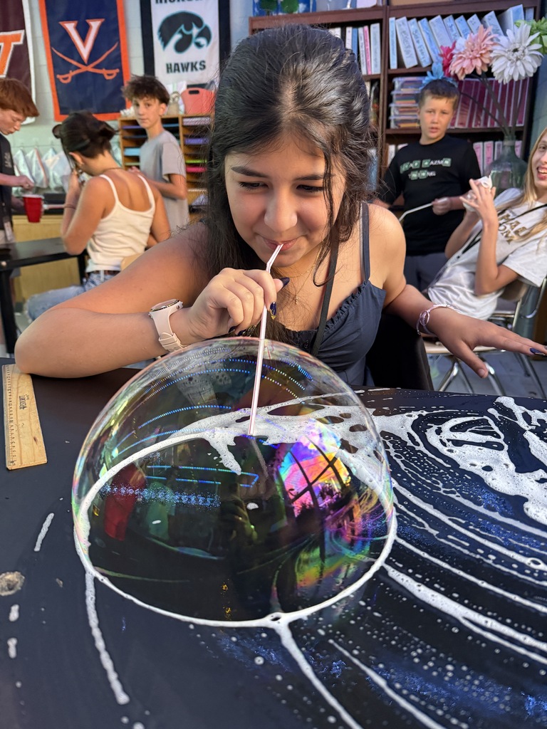 student blowing a bubble on the desk