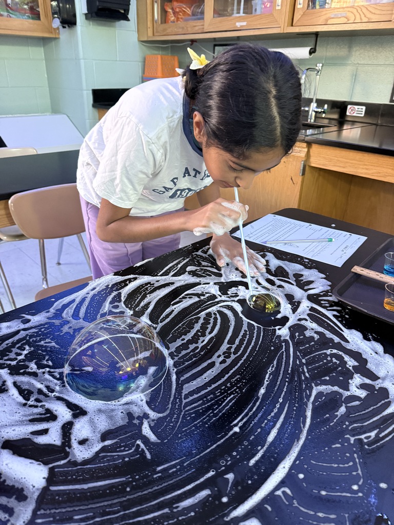 student blowing a bubble on the desk