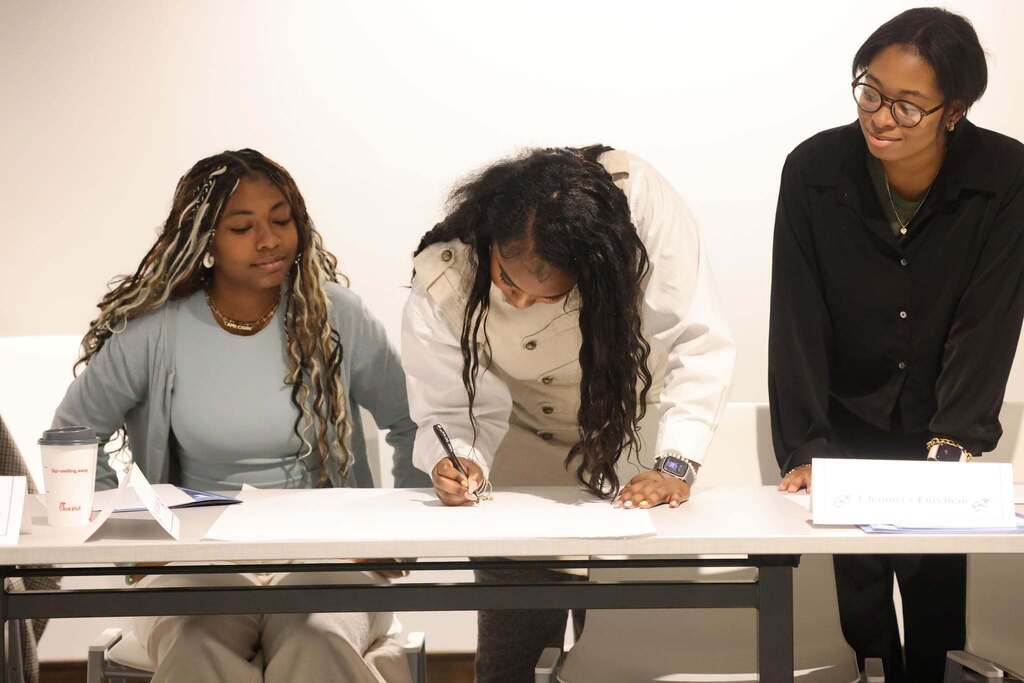 SCA members writing on a paper. 