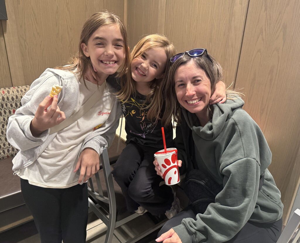 Mom and two daughters smiling and enjoying chick-fil-a