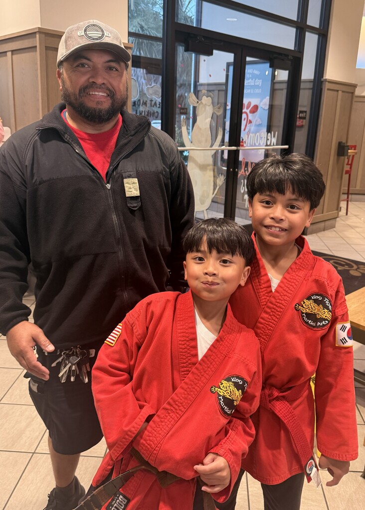 Two boys in red and dad attending Chick-fil-a