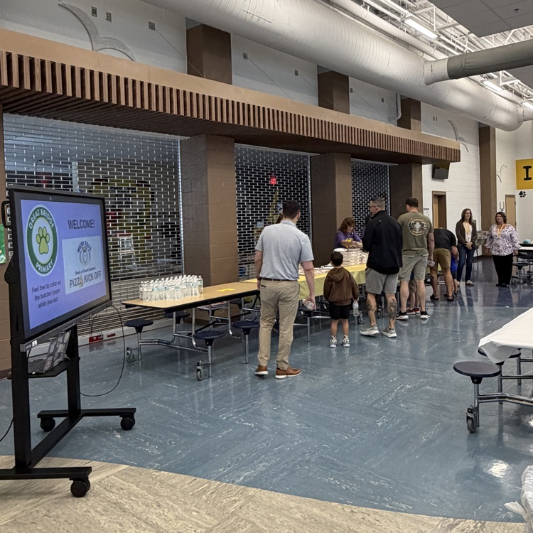 staff members serving potential Watch Dog dads at pizza night.