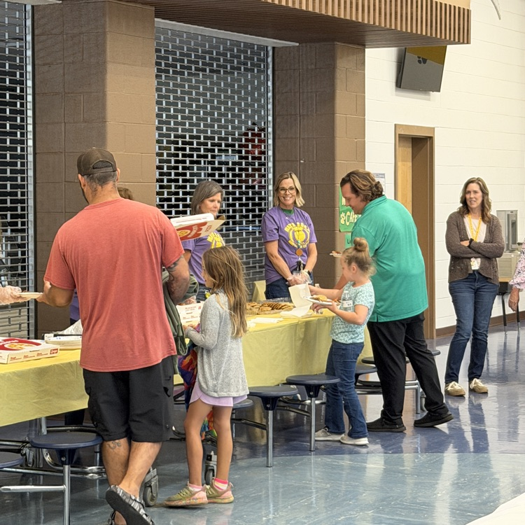 Dads and their students getting their pizza and treats at pizza night.