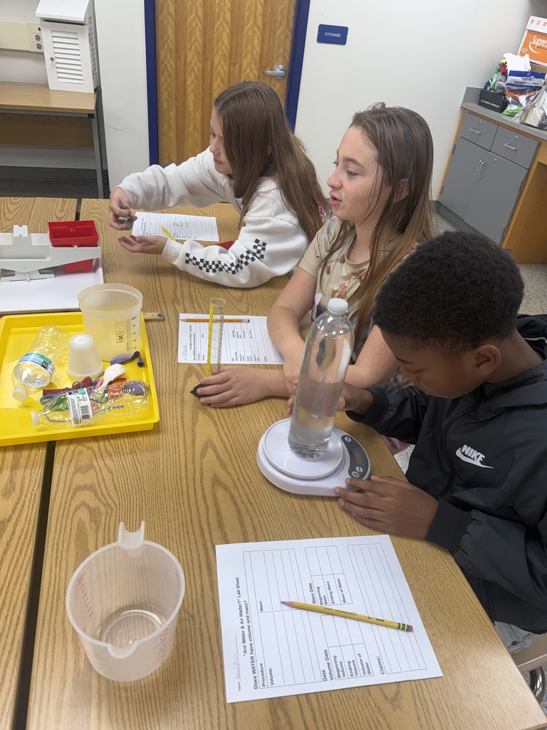 Group of students measuring a bottle filled with water.