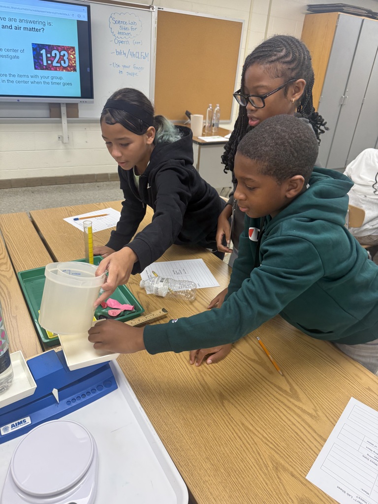Students putting materials onto a balance scale.