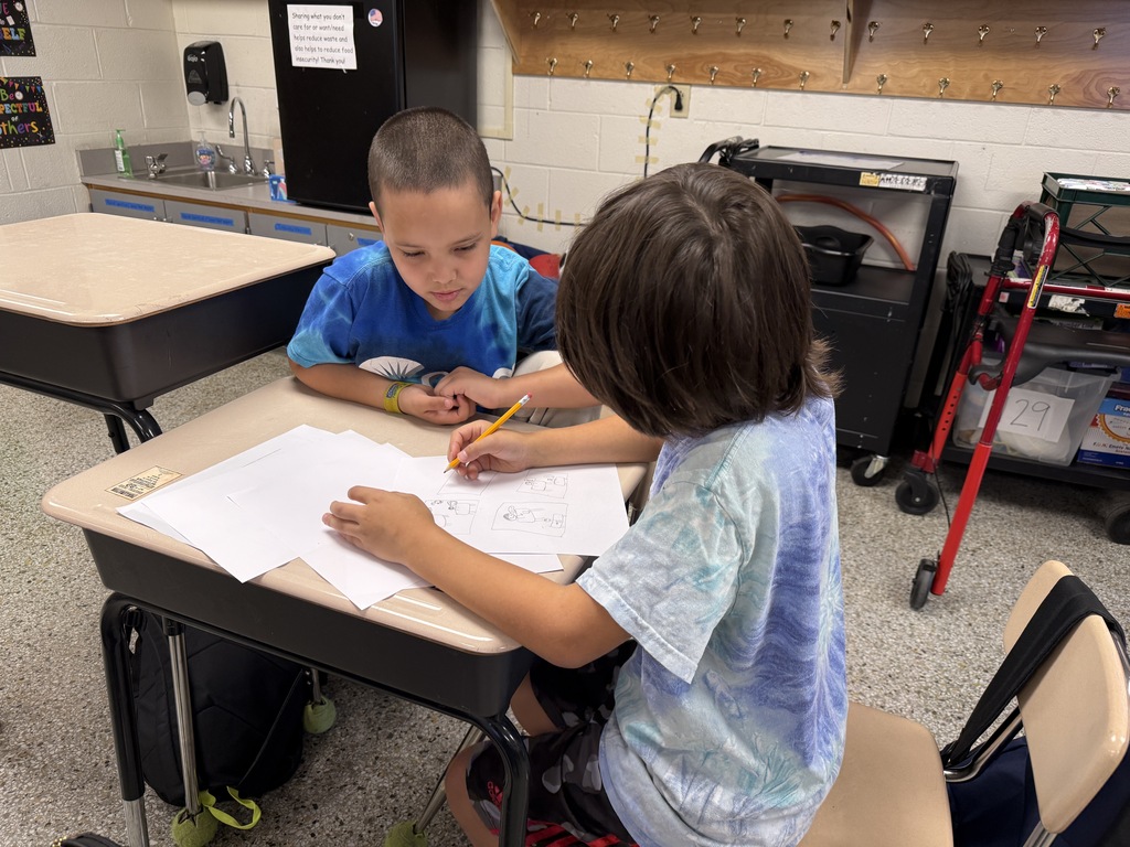 Students working with a partner to complete their PBIS project.