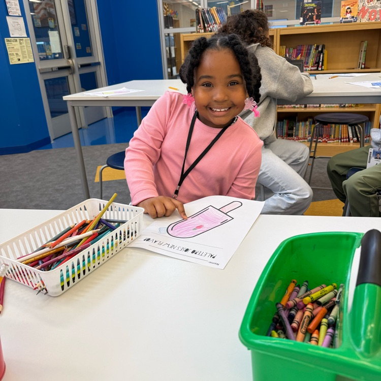 A student smiling while coloring a Hispanic heritage month popsicle