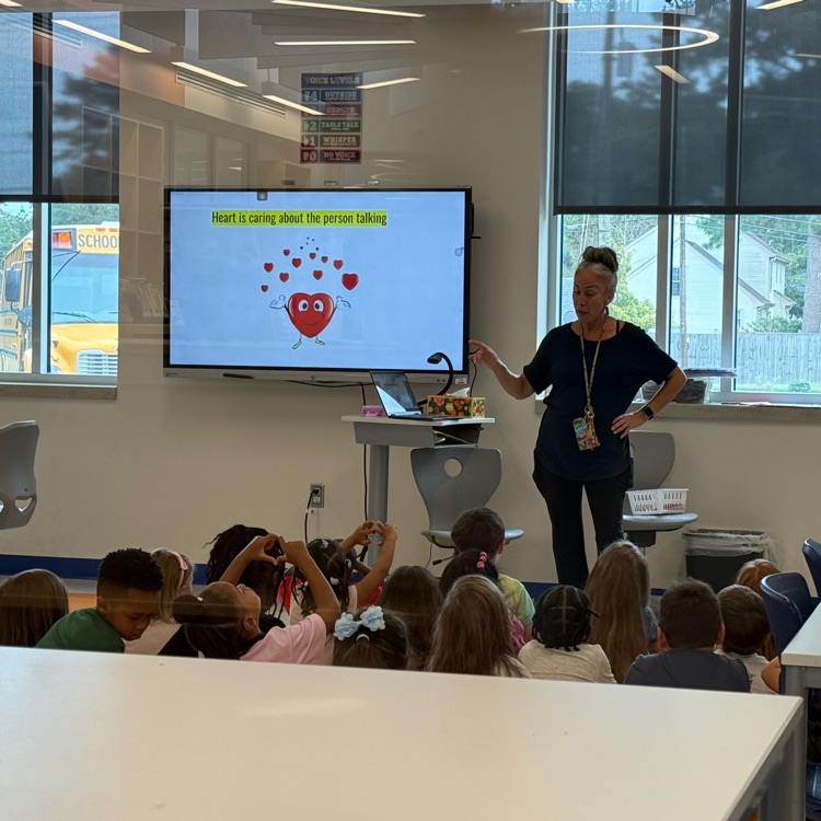 students doing the heart symbol in resource class