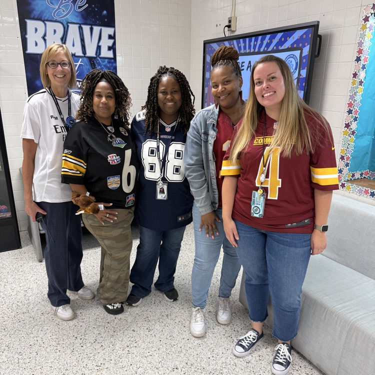 Five staff members in jerseys. 