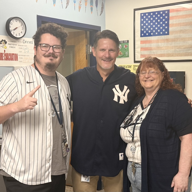 Three staff members all in Yankees gear. 