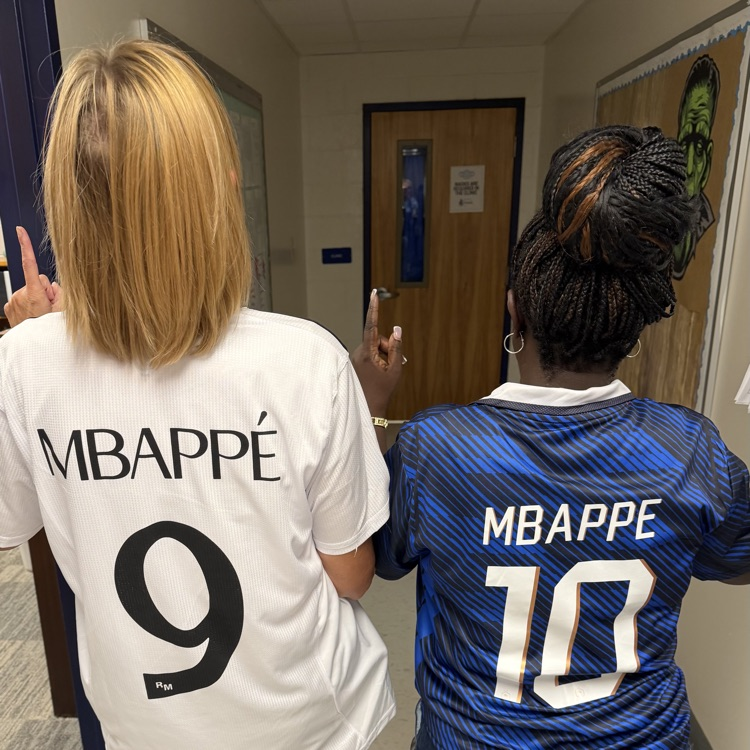 backs of two staff members with MBAPPE 