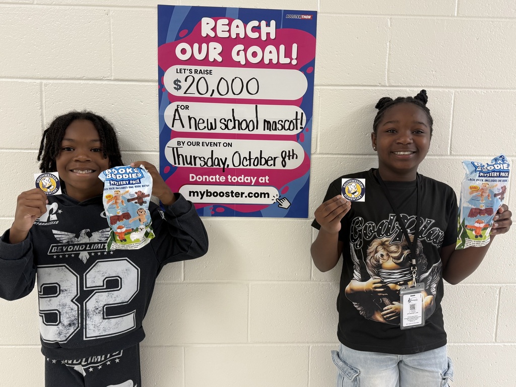 students holding prizes with a sign in the background that says reach our goal 20,000 a new mascot