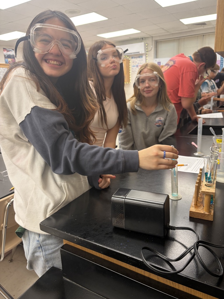 students smiling as they work on their lab