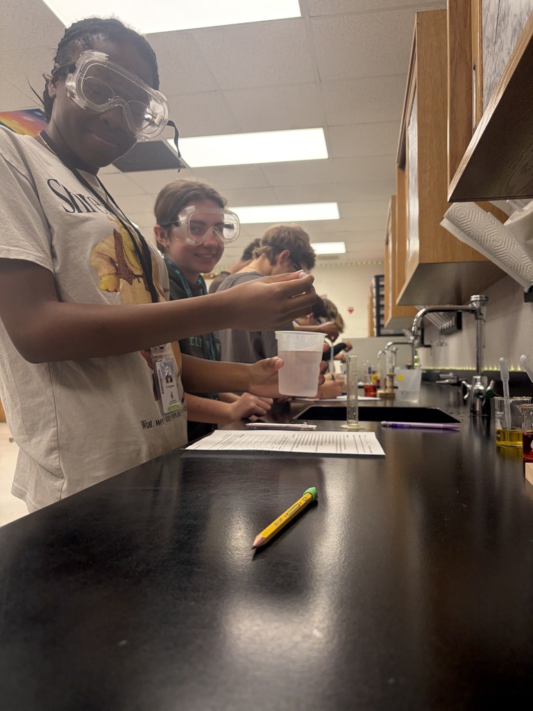 students smiling while working on their lab