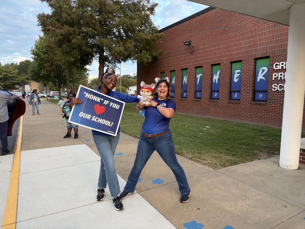 Two ladies is blue with signage for fundraiser