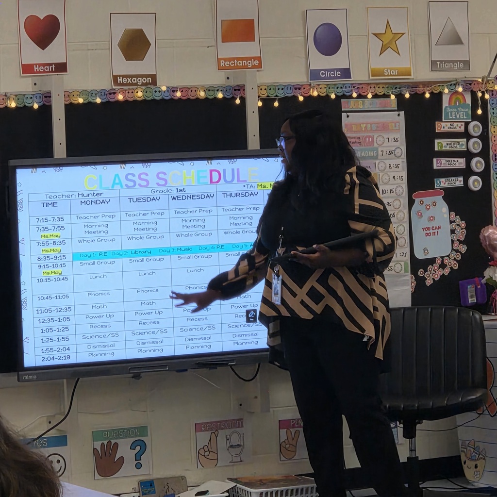 first grade teacher reviews the class schedule with her students and families