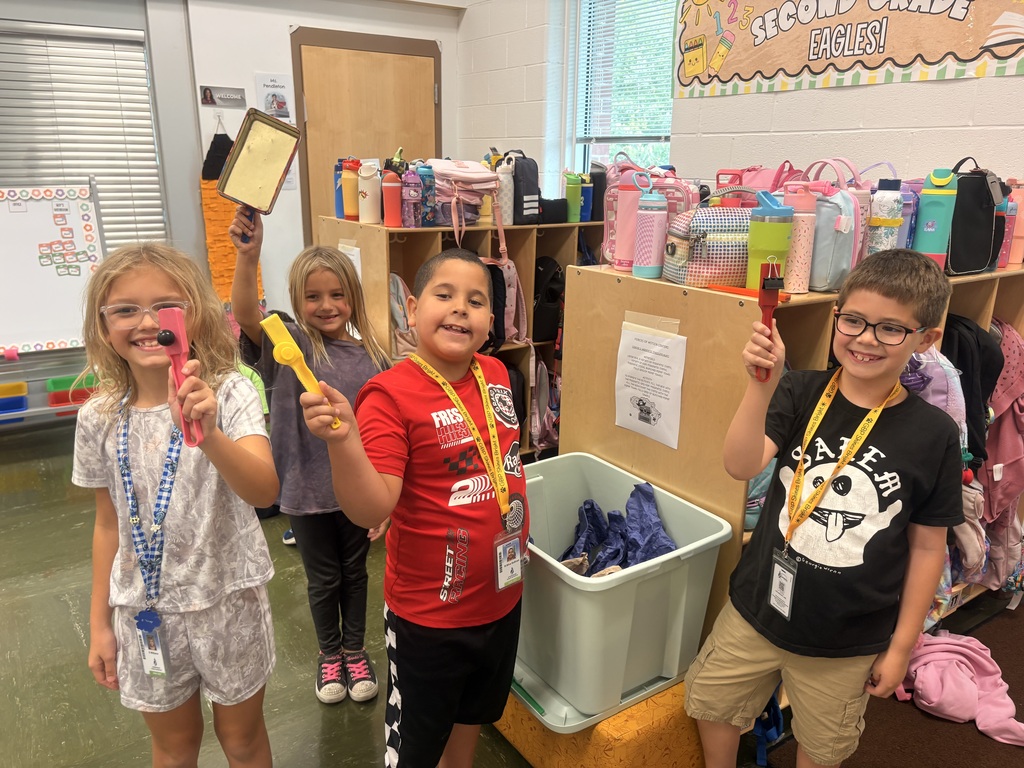 Students showing off their items they found that were magnetic.