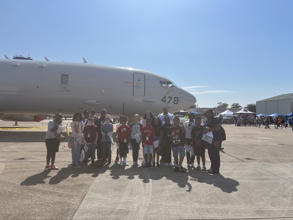 students and teachers with Navy pilot in front of airplane 