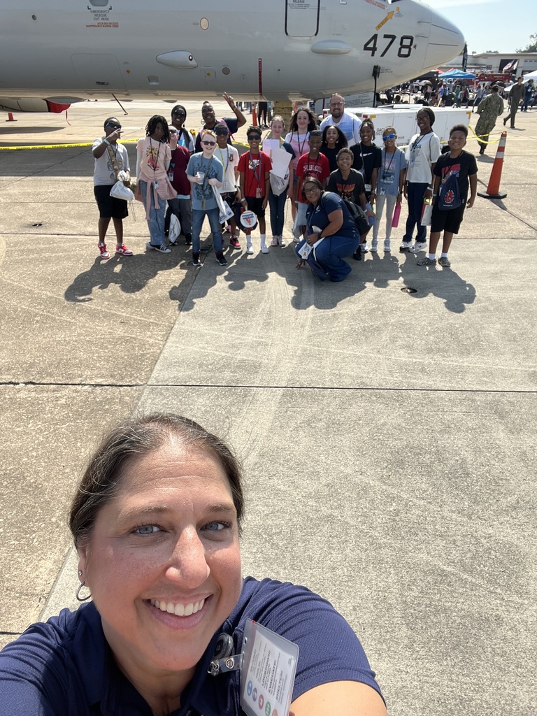 students and teachers with Navy pilot in front of airplane 