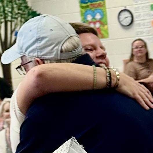 Ms. Cross hugging her dad.